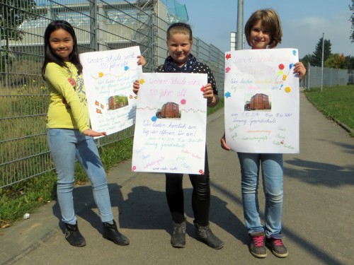 Die drei Schülerinnen warben Eckart Roßberg mit selbst gemalten Plakaten für das Jubiläumsschulfest. 